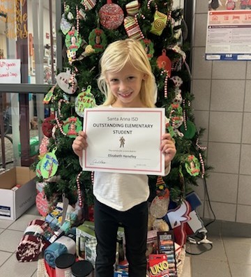 young student holding Outstanding Elementary Student paper